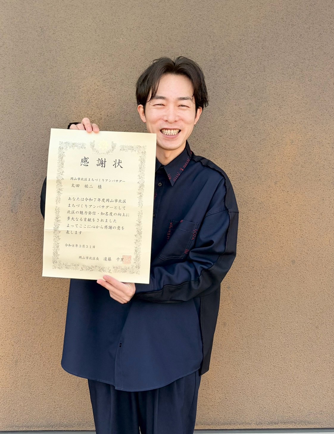 感謝状を手に笑顔を見せる太田ゆうじ